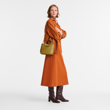 Load image into Gallery viewer, person holding the Longchamp Le Roseau Sleek Top Handle Handbag Small Olive with crossbody strap