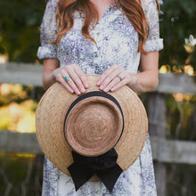 Load image into Gallery viewer, person holding a Joliet Hand-woven Straw Sun Hat with black bow