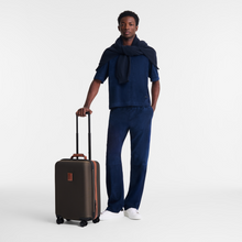 Load image into Gallery viewer, person standing next to Longchamp Boxford Cabin small Suitcase Embossed Design Brown