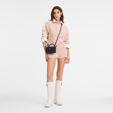 Load image into Gallery viewer, person carrying the Le Pliage Xtra XS Leather Pouch as a crossbody