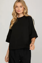 Load image into Gallery viewer, woman wearing black shirt with cream colors accents along the side of the sleeves
