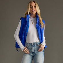 Load image into Gallery viewer, woman in a puffy Classic royal blue Vest paired with a black shirt and jeans
