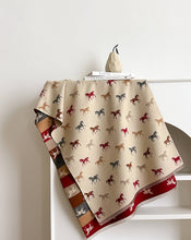 Load image into Gallery viewer, Tri Tone Equine Reversible Wrap - Red & Brown showing colorful stripes with cream colored horses on one side and cream on the other with colorful horses