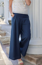 Load image into Gallery viewer, woman in the Hayley Linen Pants in blue paired with a white top