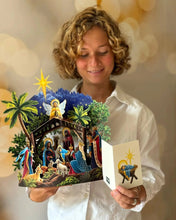 Load image into Gallery viewer, person reading the card that comes with the FreshCut Paper Starlit Nativity Greeting Card