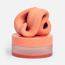 Load image into Gallery viewer, Speks Blur Calming Focus Putty in orange sitting on its storage container