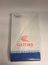 Load image into Gallery viewer, A packaged white napkin set with a blue folded corner, red 'GATORS' text, a red gator logo, and a small black script logo on the left, wrapped in clear plastic on a white background.