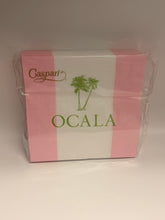 Load image into Gallery viewer, A square box of Caspari Ocala paper napkins wrapped in clear plastic, featuring pink and white horizontal stripes with green palm tree and cocktail glass graphics.