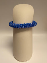 Load image into Gallery viewer, Blue beaded bracelet on a beige cushion against a beige background