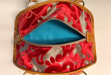 Load image into Gallery viewer, Red embroidered handbag with gold trim on a beige background