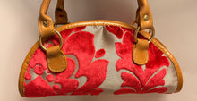 Load image into Gallery viewer, Handbag with red floral pattern and brown leather handles on a neutral background