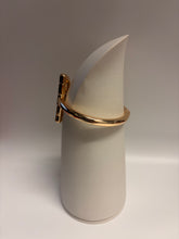 Load image into Gallery viewer, Gold bracelet on a white cylindrical stand against a light gray background