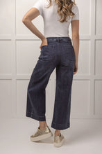 Load image into Gallery viewer, person wearing Jake Wide Leg Pants, wide leg blue jeans with white shirt and sneaker back view