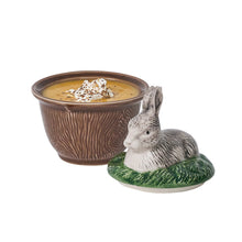 Load image into Gallery viewer, Brown bowl with wood grain design filled with soup, lid with rabbit design sitting next to it.
