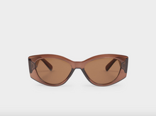 Load image into Gallery viewer, Oversized cat-eye sunglasses with translucent amber-brown frames and matching brown lenses, shown against a light gray background.