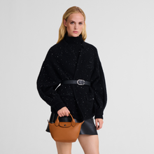Load image into Gallery viewer, person hold a Longchamp Le Pliage Xtra Top Handle Handbag - X-Small in the color Cashew