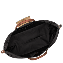 Load image into Gallery viewer, person holding the Longchamp Le Pliage Original X-Large Travel Bag in black open to show black interior