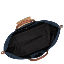 Load image into Gallery viewer, person holding the Longchamp Le Pliage Original X-Large Travel Bag in navy open to show black interior