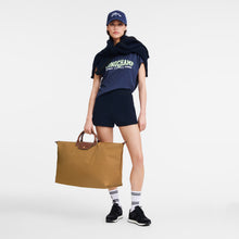 Load image into Gallery viewer, person holding the Longchamp Le Pliage Original X-Large Travel Bag in fawn by the two handles