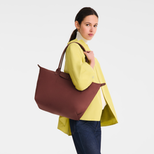 Load image into Gallery viewer, person holding the Longchamp Le Pliage One L Shoulder Bag Handbag in Burgundy under her shoulder