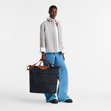 Load image into Gallery viewer, person holding expanded Longchamp Le Pliage Original Travel Bag Expandable in Black and brown leather