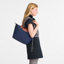 Load image into Gallery viewer, person with navy Longchamp Le Pliage Original Medium Shoulder Bag with the handle resting on her shoulder