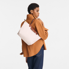 Load image into Gallery viewer, person holding Longchamp Le Pliage Original Medium Shoulder Bag in paper