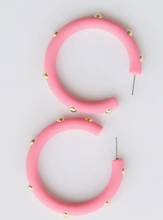 Load image into Gallery viewer, A pair of chunky pink hoop earrings decorated with small gold studs, displayed on a clean white background.