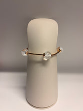 Load image into Gallery viewer, Bracelet with clear beads on a cylindrical beige stand against a gray background