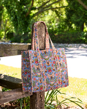 Load image into Gallery viewer, Printfresh Bee Tapestry Traveler Tote in a colorful print with bees. Bag is hung on a fence post