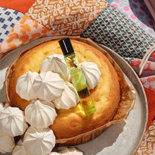 Load image into Gallery viewer, Voluspa Petal & Pair Eau De Parfum next to a cake