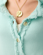 Load image into Gallery viewer, A close-up of a person wearing a gold coin pendant necklace with a bird motif, styled over a light mint green frayed knit top.
