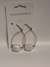 Load image into Gallery viewer, Pair of earrings with white stones and gold accents on a 'Agapanthus' branded card.