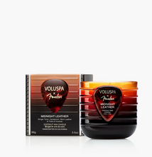 Load image into Gallery viewer, Voluspa x Fender Midnight Leather coconut wax candle and its packaging box, featuring a guitar-pick-shaped label with a red-to-brown gradient and black text, set against a clean white background.