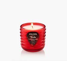 Load image into Gallery viewer, A red ribbed glass jar candle with a single lit wick, featuring a black heart-shaped label for Voluspa x Fender Strawberry Rush Coconut Wax.