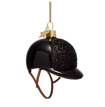 Load image into Gallery viewer, A glossy black equestrian helmet Christmas ornament with a textured black glitter crown, brown leather-style straps, and a gold hanging loop on a white background.