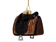 Load image into Gallery viewer, A miniature black and brown saddle ornament with glittery brown sides, a gold hanging chain, and a small gold star charm.