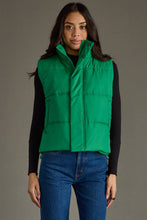 Load image into Gallery viewer, woman in a puffy Classic Green Vest paired with a black shirt and jeans with the vest closed