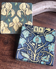 Load image into Gallery viewer, two coasters one with a yellow floral patter on a green background one with a light blue and yellow floral pattern on a darker blue background