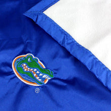 Load image into Gallery viewer, close up of gator logo and white back of the blanket
