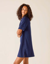 Load image into Gallery viewer, person wearing Mersea French Terry Polo Dress in blue side view showing detailing on short sleeves and small vent at the side seam