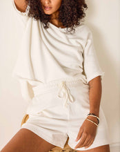 Load image into Gallery viewer, woman sitting wearing Mersea Frenchie Pajamas Shorts in white paired with a matching top