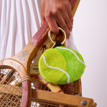 Load image into Gallery viewer, person holding the Mary Tennis Ball Beaded Coin Purse Yellow Green by it's gold hook handle and also holding tennis rackets