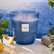Load image into Gallery viewer, Voluspa Mediterranean Lemon 5-Wick Hearth Candle with ocean behind it