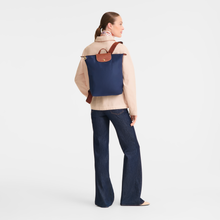 Load image into Gallery viewer, person wearing Longchamp Le Pliage Original Backpack in navy with brown leather trimming
