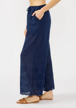Load image into Gallery viewer, person wearing wide leg blue cotton pants with their hand in the side pocket 
