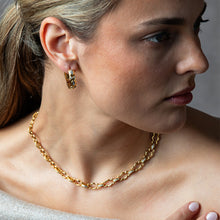 Load image into Gallery viewer, person wearing Capucine de Wulf Huggie Hoop Earrings and a matching gold chain
