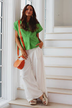 Load image into Gallery viewer, woman in the Hayley Linen Pants in white paired with a green short sleeve top
