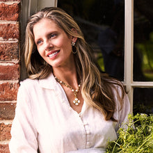 Load image into Gallery viewer, person wearing gold jewelry including the Capucine de Wulf Berry Clover Teardrop Earrings
