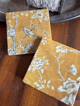 Load image into Gallery viewer, two coasters with black and white bird and floral designs on a yellow background
